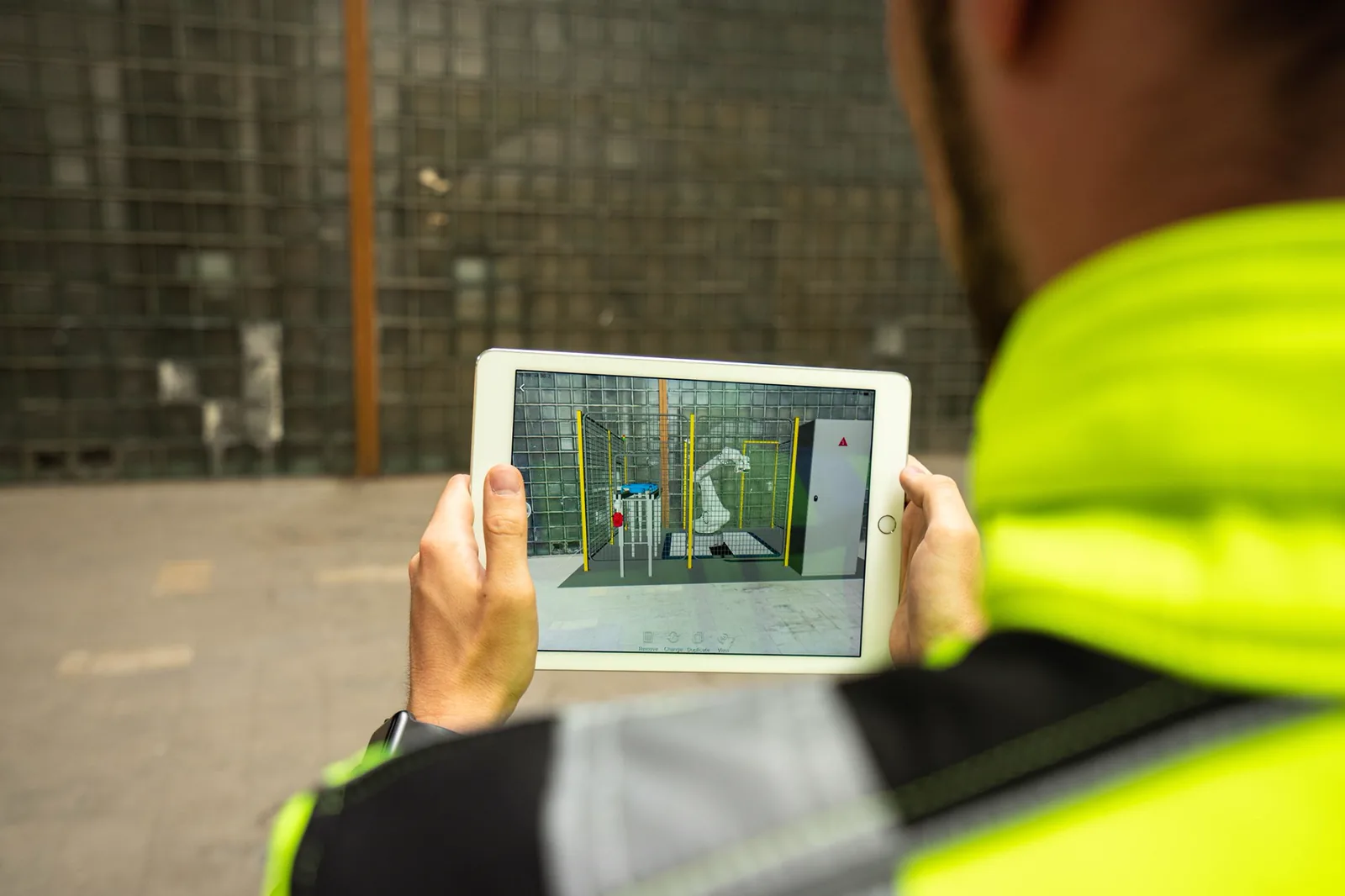Monteur betrachtet eine 3D-Planung auf dem Tablet direkt in der Halle